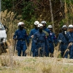 　前日にスニーカーが発見された山中付近の捜索に向かう京都府警の捜査員＝１３日午後０時５９分、京都府南丹市