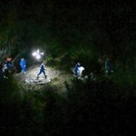 　身元不明の遺体が見つかったとみられる京都府南丹市の現場付近を調べる捜査員ら＝１３日午後７時３８分（共同通信社ヘリから）