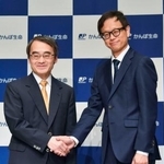　かんぽ生命保険の次期社長に内定している大西徹副社長（右）と握手する谷垣邦夫社長＝１３日午後、東京都千代田区