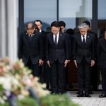 　熊本地震の「前震」から１０年となり、震災記念公園で黙とうする熊本県益城町の西村博則町長（左端）ら＝１４日午前、益城町