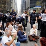 　１３日、米ニューヨーク・マンハッタンで、通りに座り込むデモ参加者ら（共同）