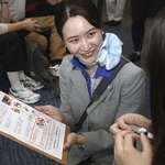 　モバイルバッテリーの持ち込みに関して、乗客に協力を求める全日空グループの地上職員＝２０２５年７月、羽田空港