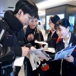 　モバイルバッテリーの取り扱い変更を利用客にチラシで周知する航空会社の関係者＝１４日午後、羽田空港