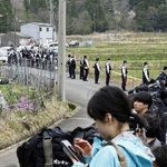 　安達結希さんの自宅付近に集まった報道陣と、警戒にあたる警察官＝１５日、京都府南丹市