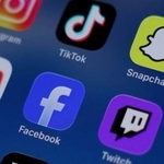 　スマートフォンに表示されたフェイスブック（中央）などＳＮＳのアプリ＝２０２５年１２月（ロイター＝共同）