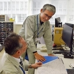 　石川県珠洲市役所で業務主任の門前修さん（手前）と話す熊本市職員の後藤升郎さん＝１４日