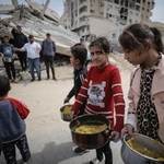 　１５日、パレスチナ自治区ガザ北部ガザ市で、食料の配給を受け取る避難民ら（ゲッティ＝共同）