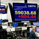 　上げ幅が一時９００円を超え、節目の５万９０００円を回復した日経平均株価を示すモニター＝１６日午前、東京都港区の外為どっとコム