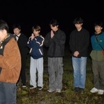 　東海大生が犠牲になったアパート倒壊現場で手を合わせる卒業生の橋村さくらさん（左端）と現役学生ら＝１６日未明、熊本県南阿蘇村