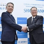 　資本業務提携を発表し、握手する池田泉州ＨＤの阪口広一社長（左）と滋賀銀行の久保田真也頭取＝１７日午後、大阪市