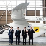 　電動航空機の前でポーズをとる北九州市の武内和久市長（左から２人目）ら＝１７日午前、北九州空港（北九州市提供）