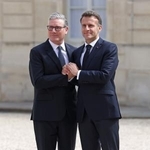 　パリのフランス大統領府で、会合の前に英国のスターマー首相（左）を出迎えるフランスのマクロン大統領＝１７日（ロイター＝共同）