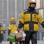 　北京市内の繁華街で働く出前アプリ「美団」の配達員＝２０２５年１２月（共同）