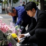 　乗用車暴走事故から７年となり、慰霊碑に献花する松永拓也さん（右）と真菜さんの父上原義教さん＝１９日午後、東京・池袋