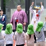 　こいのぼりの掲揚式に参加した（奥左から）こども家庭庁の渡辺由美子長官、大相撲の出羽ノ龍関、魚類学者でタレントのさかなクン＝２０日午前、東京・霞が関