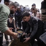 　食料の配給を受ける避難民ら＝１５日、パレスチナ自治区ガザ市（ゲッティ＝共同）