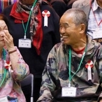 　大分県立学びケ丘中の入学式を終え、他の新入生らと談笑する尾畠春夫さん（右）＝２１日午後、大分市