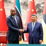 　調印式で握手する中国の習近平国家主席（右）とモザンビークのチャポ大統領＝２１日、北京の人民大会堂（共同）