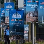 　２１日、パキスタン・イスラマバードで、米イラン協議に関する掲示物付近を歩く警察官（ＡＰ＝共同）