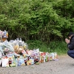 　安達結希さんの遺体が遺棄された現場付近で手を合わせる人＝２２日午後、京都府南丹市