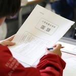 　全国学力テストで問題用紙を手に開始を待つ児童＝２３日午前、東京都内の小学校（代表撮影）