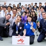 　味の素本社を訪れ、社員らと記念撮影に応じるフィギュアスケート女子の坂本花織（中央左）＝２３日、東京都内