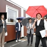 　アジア・アジアパラ大会で選手の宿泊拠点となる仮設のコンテナハウスを視察する谷本歩実アスリート委員長（手前右）ら＝２３日午前、名古屋市