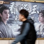 　北京市内に設置された中国の恋愛時代劇「逐玉」を宣伝する看板。左は将軍役の俳優張凌赫さん＝８日（共同）