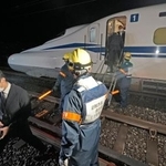 　ＪＲ東海の訓練で、停止した新幹線の車両から線路に降りる乗客役＝２４日未明、静岡市