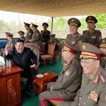 　北朝鮮軍の迫撃砲の訓練を視察する金正恩朝鮮労働党総書記（手前右から３人目）＝２５日（朝鮮中央通信＝共同）