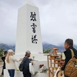 　マンザナー強制収容所跡地の「慰霊塔」で、献花する人たち＝２５日、米カリフォルニア州インディペンデンス（共同）