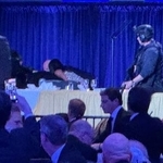 　２５日、ホワイトハウス記者会主催の夕食会会場で起きた大きな音に反応した大統領警護隊員ら＝ワシントン（ＡＰ＝共同）