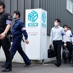 　家宅捜索のため畜産加工会社「水迫畜産」の加工工場に向かう鹿児島県警の捜査員＝２６日午前、鹿児島市