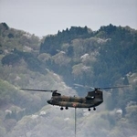 　山林火災の消火活動のため、海水をくみ上げるヘリコプター＝２７日午前、岩手県大槌町