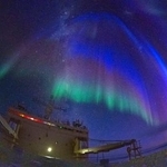 　しらせの艦橋に光が降り注ぐようなオーロラ＝３月、南極海（魚眼レンズ使用、小野数也さん提供）