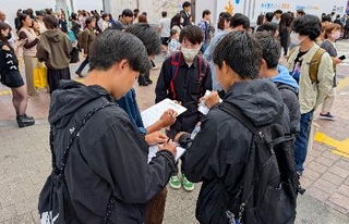 　市民団体「日本平和委員会」が実施した、憲法に関するアンケートに答える若者たち＝３日午後、東京・渋谷