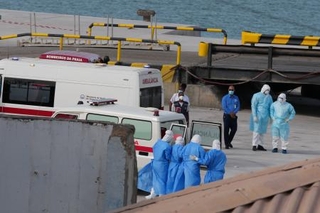 　カボベルデの首都プライアの港で６日、クルーズ船から患者を退避させる防護服姿の医療従事者ら（ＡＰ＝共同）