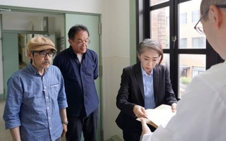 　京都大吉田寮「現棟」の建て替え方針撤回などを求め、声明文を提出する駒込武教授（奥中央）ら＝１４日午後、京都市左京区