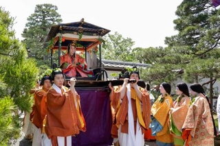 　色鮮やかな平安装束姿で出発する、葵祭のヒロイン「斎王代」の塩見真桜さん＝１５日午前、京都市