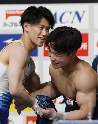 　体操ＮＨＫ杯第２日を終え、健闘をたたえ合う橋本大輝（左）と岡慎之助＝東京体育館