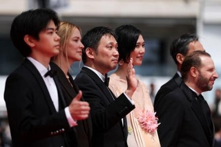 　カンヌ国際映画祭で「急に具合が悪くなる」のレッドカーペットに登場した濱口竜介監督（中央）とキャスト陣＝１５日、カンヌ（ロイター＝共同）