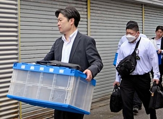 　若山哲夫容疑者の自宅から押収物を運び出す捜査員＝２０日午前１０時５５分、新潟県胎内市