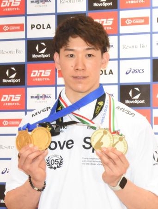 　バレーボール男子イタリア１部リーグ、ペルージャで獲得したメダルを手にポーズをとる石川祐希＝２１日、羽田空港