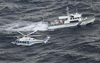 　米軍オスプレイの事故現場海域で捜索を続ける海上保安庁の巡視艇とヘリコプター＝２０２３年１１月３０日、鹿児島県・屋久島沖（共同通信社ヘリから）