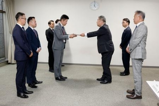 　さとふるの青木大介副社長（中央左）らに対し、手数料引き下げの要請書を渡す寺崎秀俊自治税務局長＝２２日午後、総務省