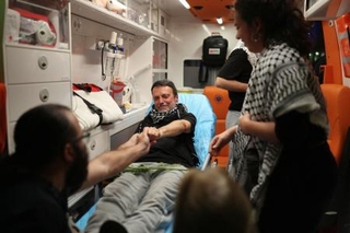 　イスラエル軍に拘束された後、ギリシャ・アテネ国際空港に到着し、救急車内に横たわる「グローバル・スムード船団」の活動家＝２２日（ロイター＝共同）