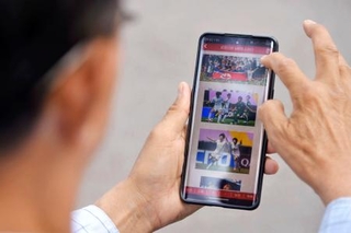 　サッカーの女子ＡＣＬで北朝鮮のチームが優勝したニュースを読む市民＝２４日、平壌（共同）