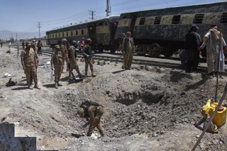 　パキスタン南西部で２４日に発生した爆発の現場を調べる軍関係者ら（ＡＰ＝共同）