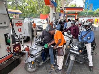 　バイクで混雑するインド・ニューデリーのガソリンスタンド＝１８日（共同）