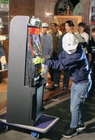 　押収されるパチスロ機＝２４日、東京都新宿区